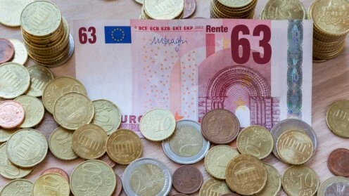 llustration zur Rente mit 63: Euro-Banknote mit der Zahl 63 sowie Euro-Münzen als Symbol für Frührente, Rentenansprüche und Altersvorsorge.