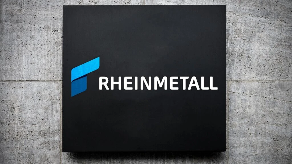Rheinmetall-Logo auf schwarzem Schild an Betonwand