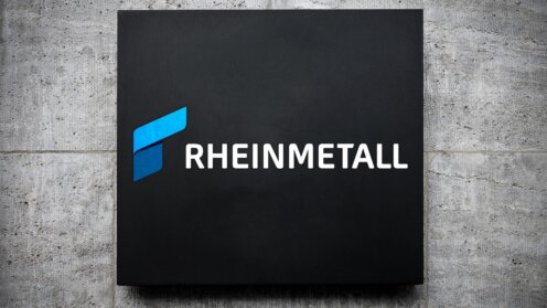 Rheinmetall-Logo auf schwarzem Schild an Betonwand