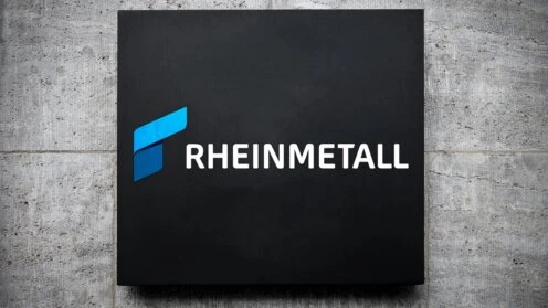 Rheinmetall-Logo auf schwarzem Schild an Betonwand