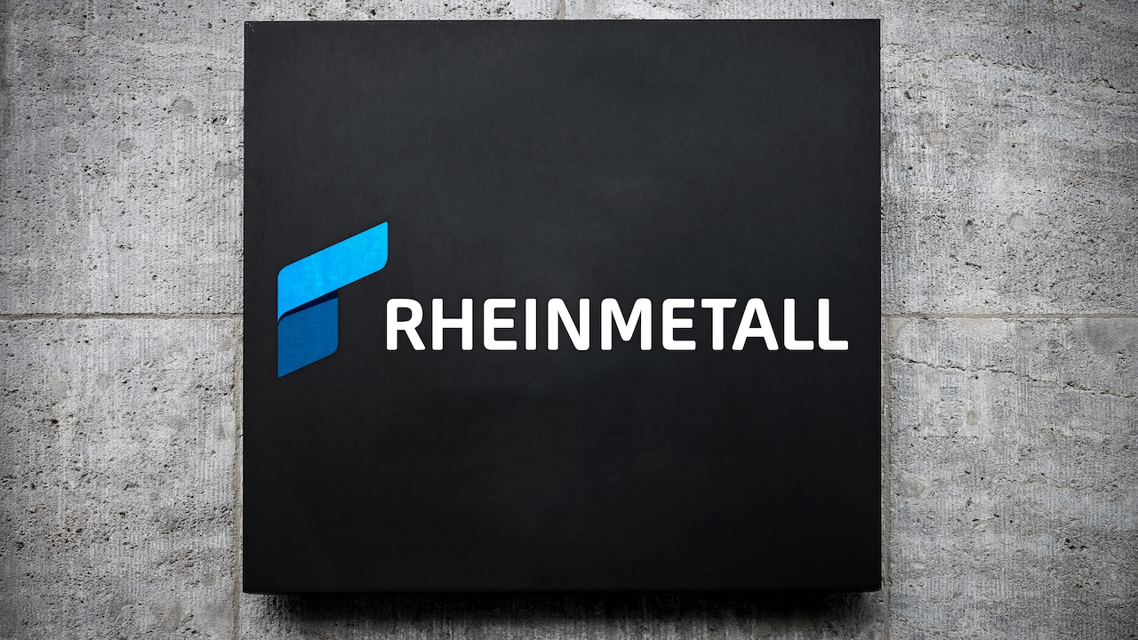 Rheinmetall-Logo auf schwarzem Schild an Betonwand