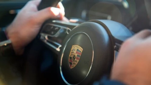 Ein Porschefahrer hält mit seine beiden Händen das Lenkrad