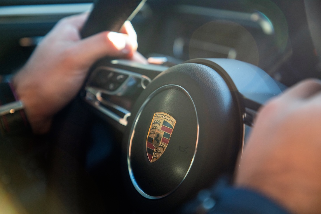 Ein Porschefahrer hält mit seine beiden Händen das Lenkrad