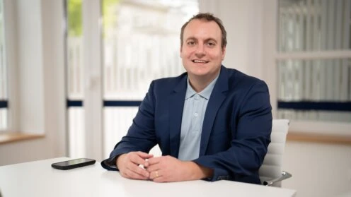 André Heid sitzt an einem Tisch im Büro