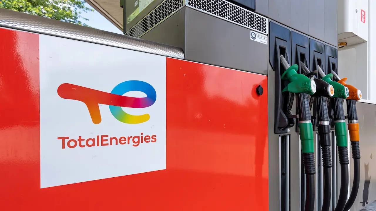 Zapfsäule einer TotalEnergies-Tankstelle mit Firmenlogo und mehreren Zapfpistolen in Grün, Schwarz und Orange.